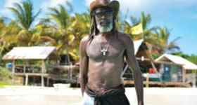 O cantor de reggae Bankie Banx em frente ao The Dune Preserve, bar construído com pedaços de madeira e materiais vindos do mar (Divulgação / Anguilla Touri