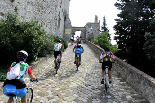 Ciclistas no Castelo malatestiano de Montefiore Conca, Itália